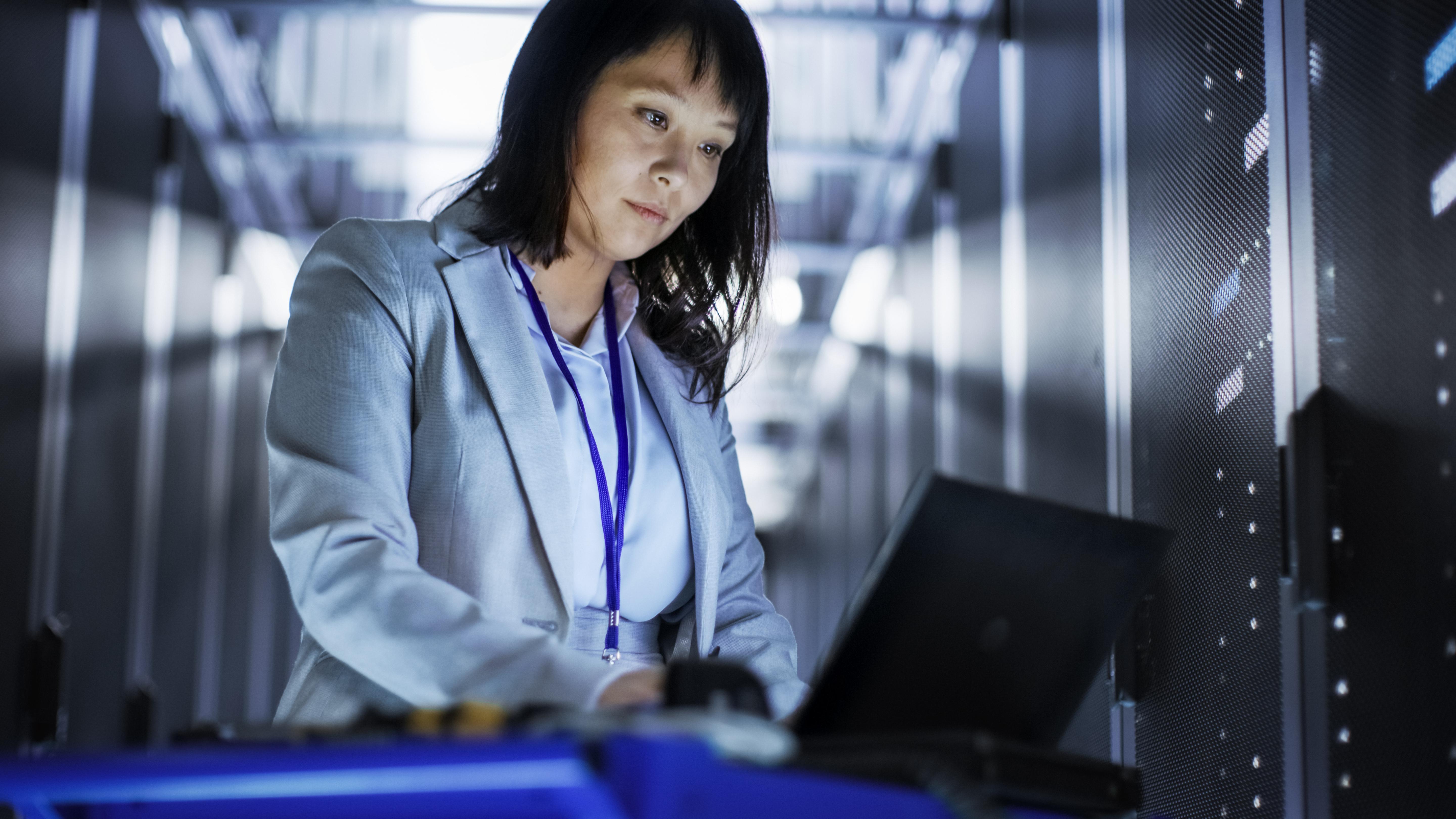Woman On Laptop In Server Room